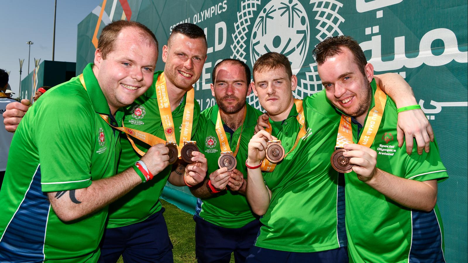 Members of Special Olympics Ireland team holding up medals in celebration