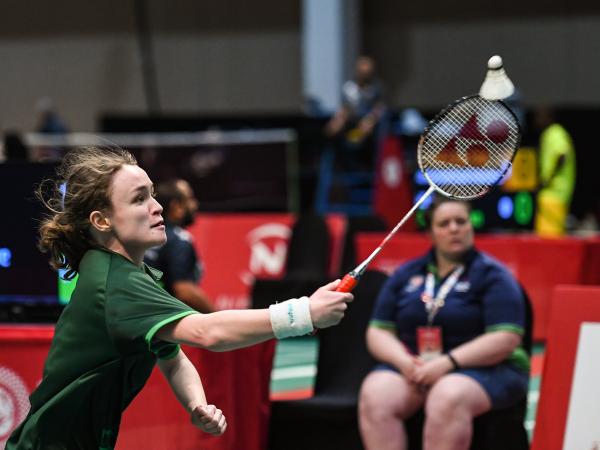 Girl aiming for shuttlecock with racquet