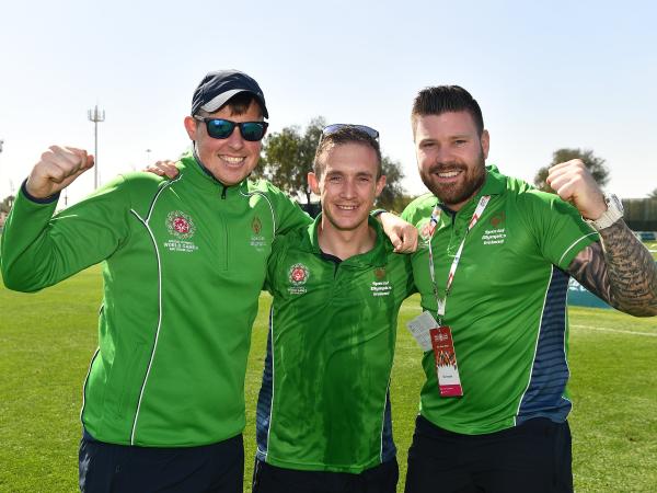 three men smile to camera wearing ireland jerseys