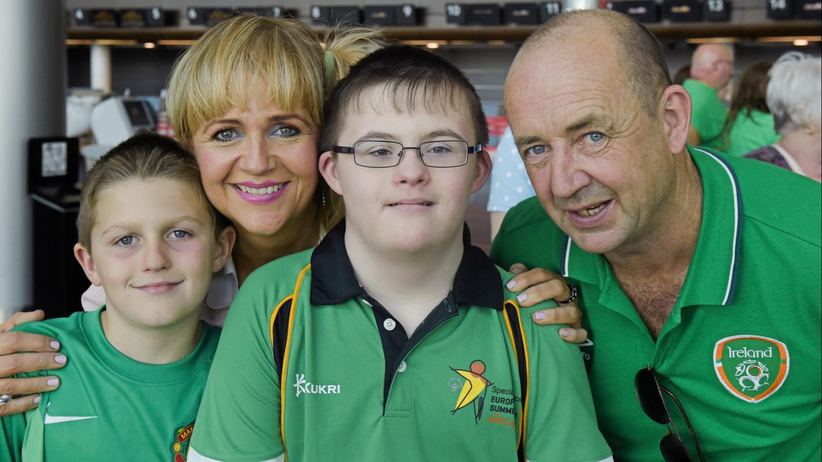 Smiling Family - Special Olympics athlete pictured with his Mum and Dad and younger brother
