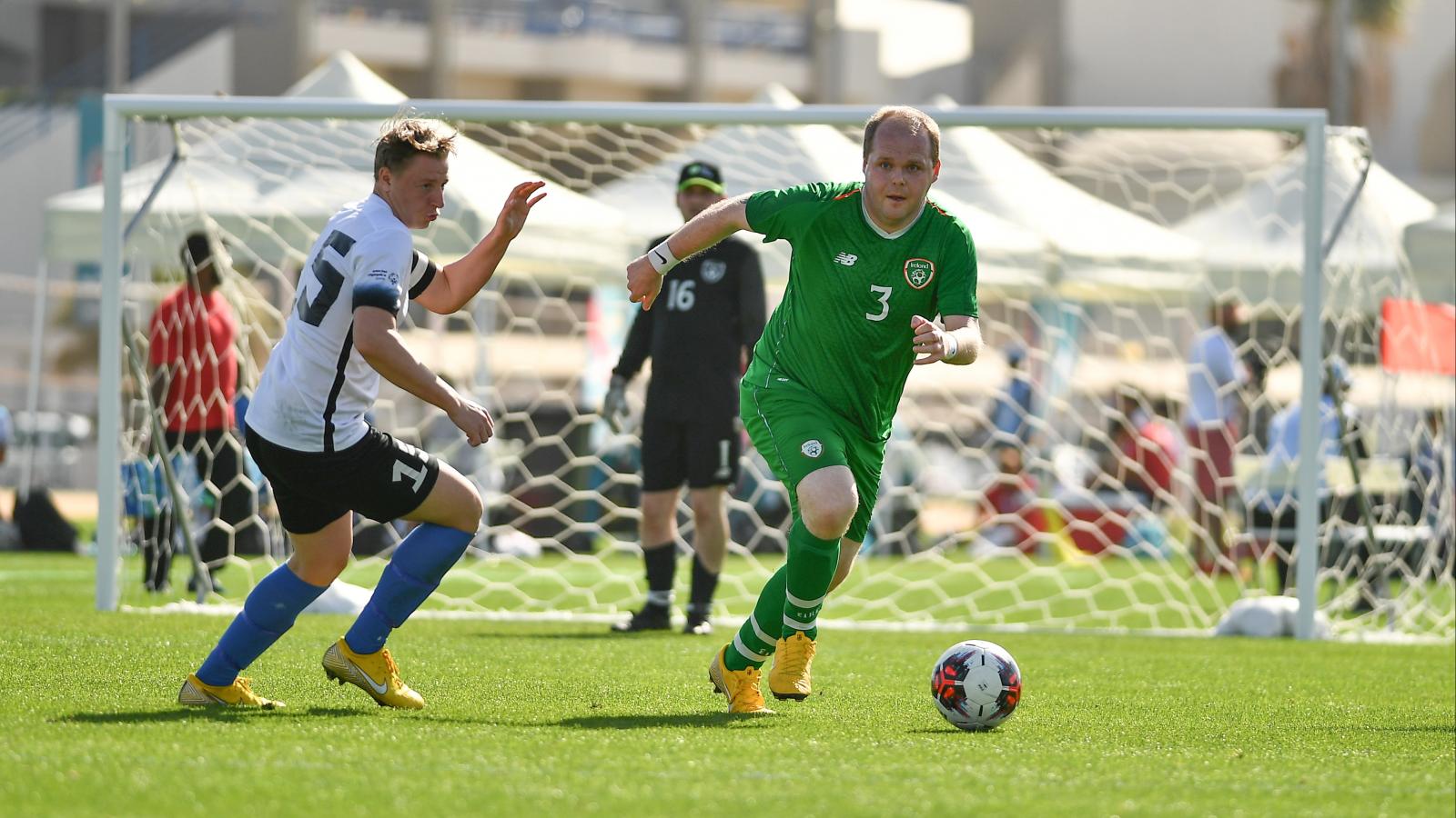 Football player dribbling ball away from opponent