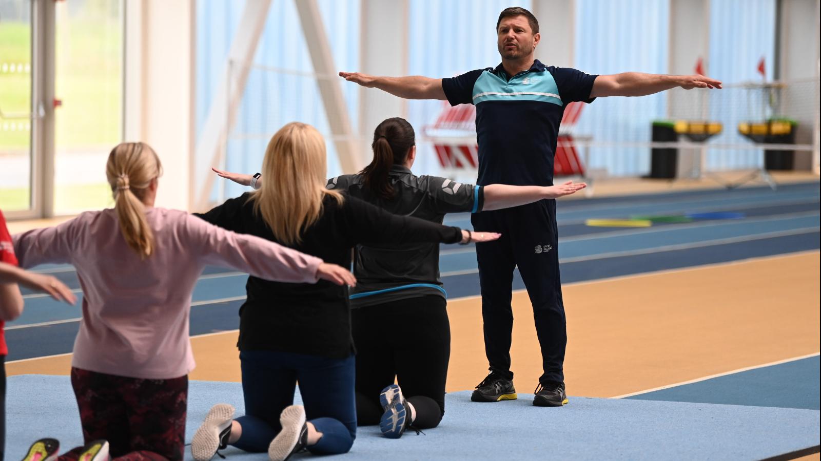 People kneeling arms out wide for balance